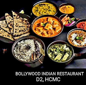 The image displays a variety of Indian dishes served in bowls and plates on a dark background with the text 'BOLLYWOOD INDIAN RESTAURANT D2, HCMC' pro