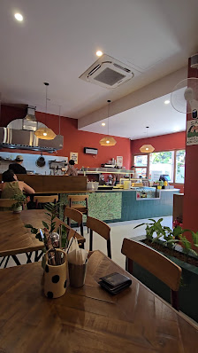 The image shows an interior view of a restaurant or cafe in Thao Dien, Saigon. The space is well-lit with natural light coming through the windows and