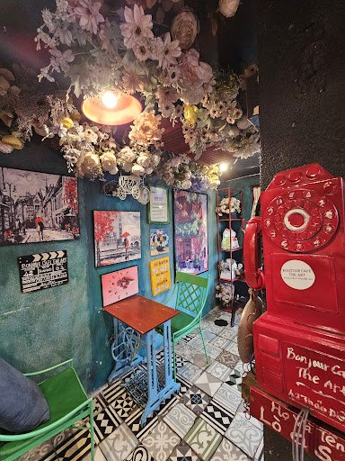 This image depicts an interior space that appears to be a themed café or restaurant. The decor includes vibrant colors and eclectic elements such as a