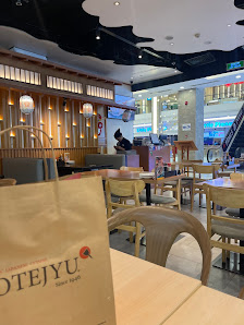 The image shows an interior view of a restaurant named 'OTEJUYU' with wooden decor and modern lighting fixtures on the ceiling.
