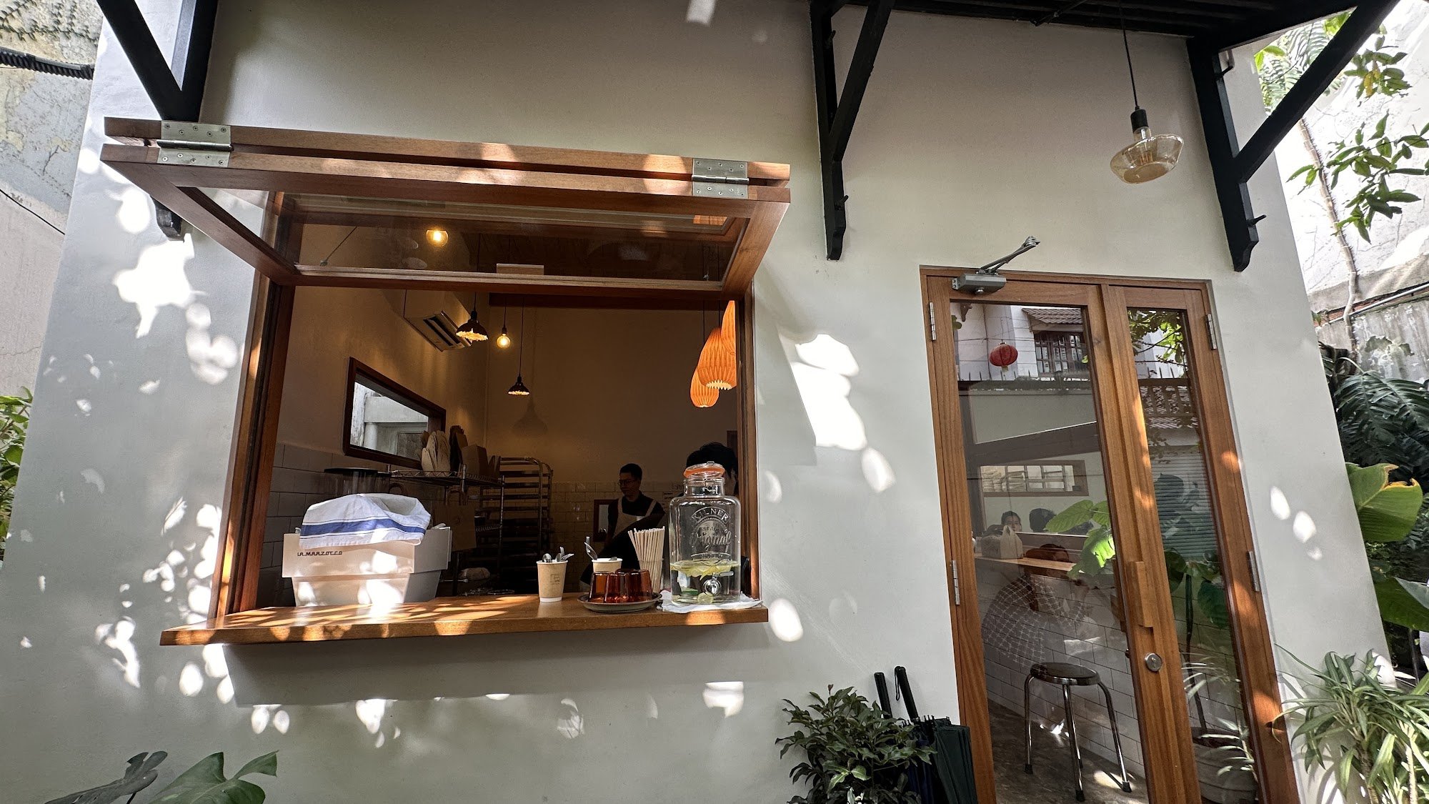 This image shows an interior view of a cafe or coffee shop located in Thao Dien, Saigon. The establishment has a modern and cozy design with wooden el