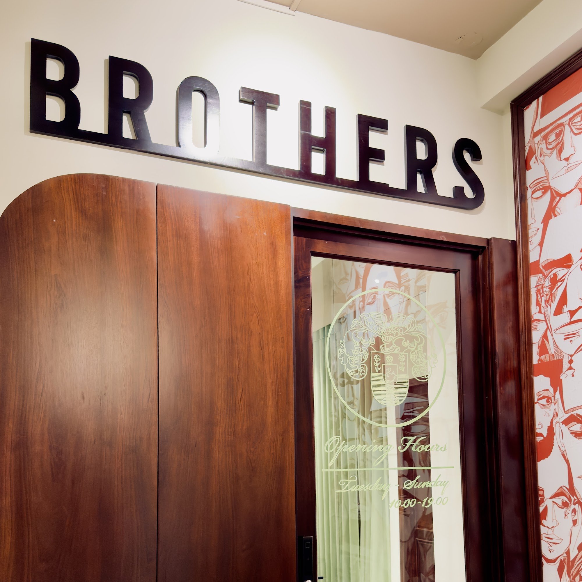 The image shows an interior view of a venue named 'BROTHERS' with wooden paneling and large lettering on the wall above it.