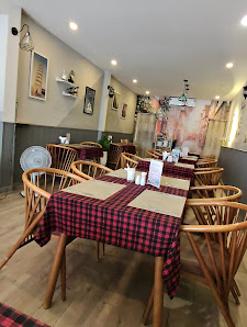 The image shows an interior view of a restaurant or dining area featuring wooden chairs and tables with red checkered tablecloths, set against a backd