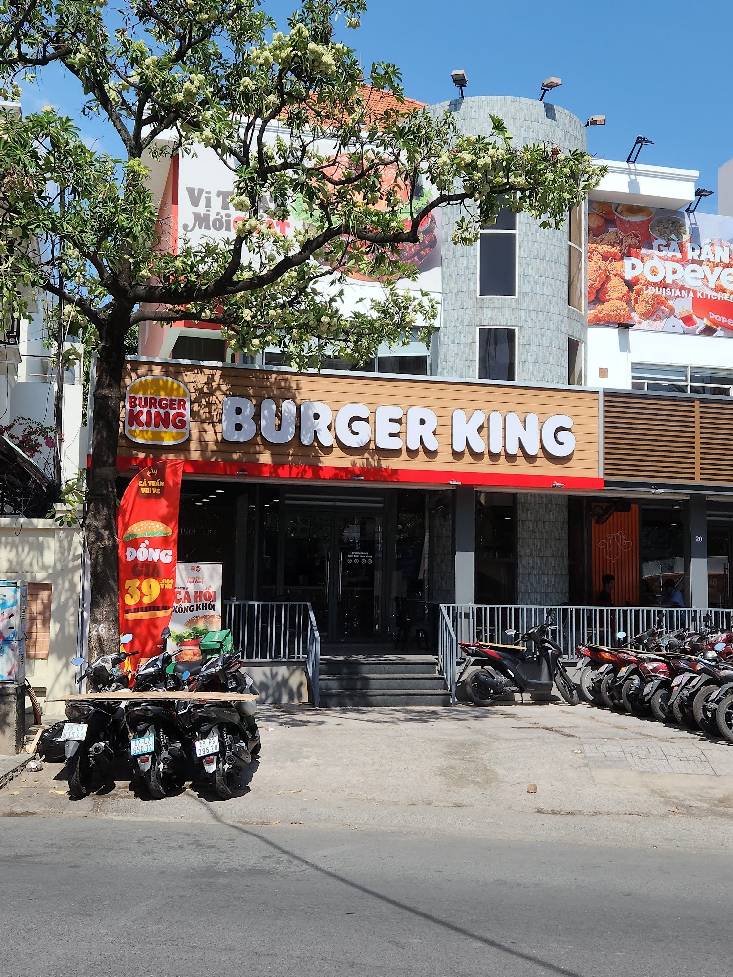 The image shows an exterior view of a Burger King restaurant located in Thao Dien, Saigon. The establishment is prominently displayed with its recogni