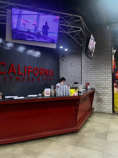 The image shows an interior view of a fitness club named 'California Fitness & Yoga'. The reception desk is prominently featured with the brand's name
