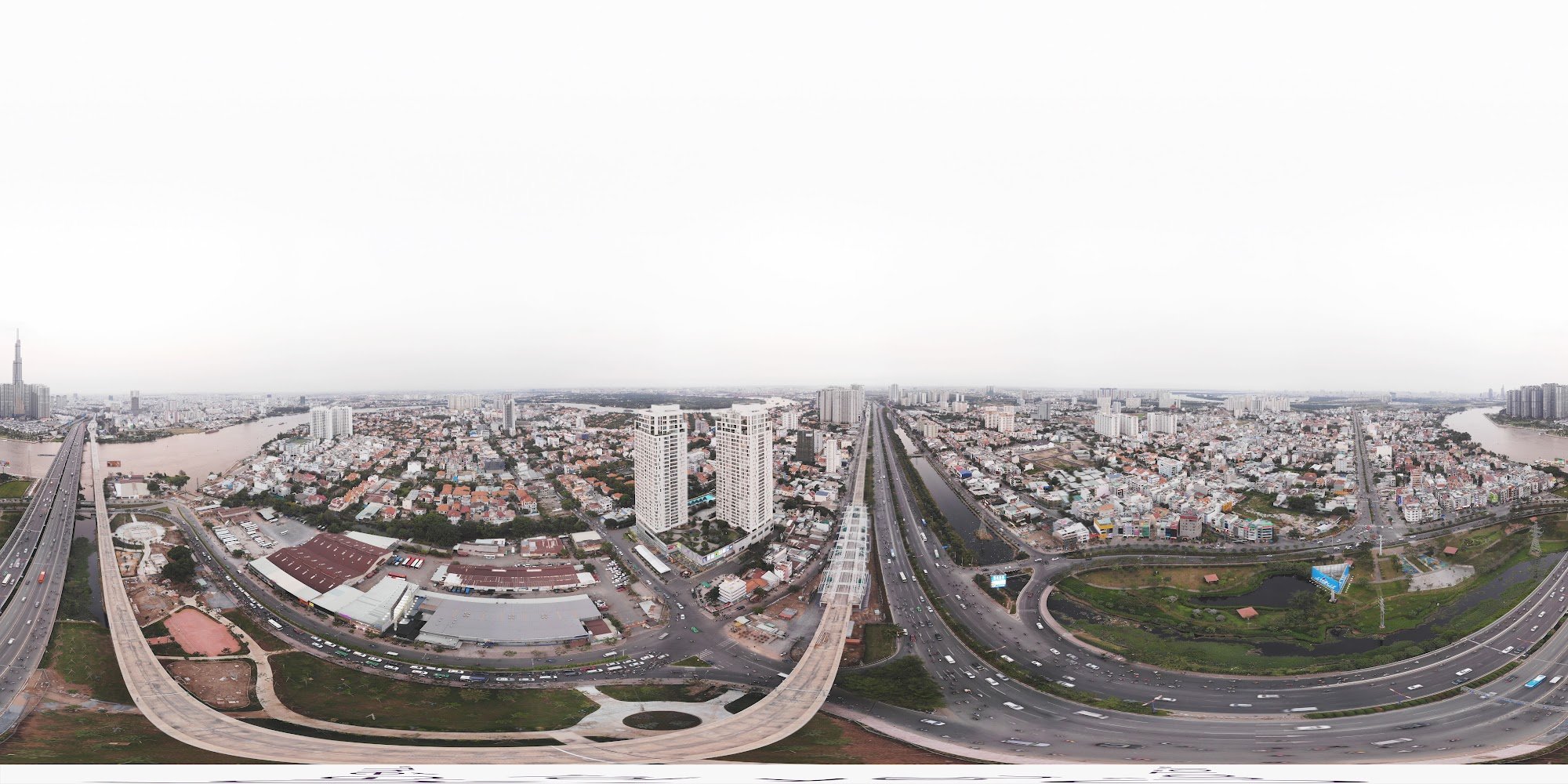 This image is a panoramic view of an urban area showing multiple highways and bridges intersecting with each other. The scene includes high-rise build