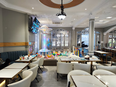 The image shows an interior view of a modern restaurant or cafe in Thao Dien, Saigon. The space is well-lit with natural light coming through the wind