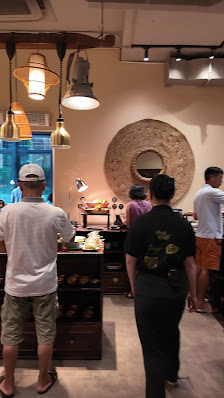 The image depicts the interior of a venue in Thao Dien, Saigon. It features several people (including a person in a white shirt and cap, another in a 