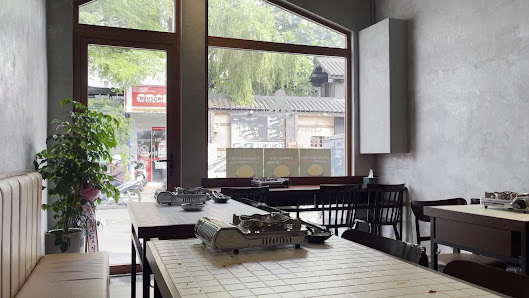 The image shows an interior view of a restaurant or cafe located in Thao Dien, Saigon. The space is modern and minimalist with large windows allowing