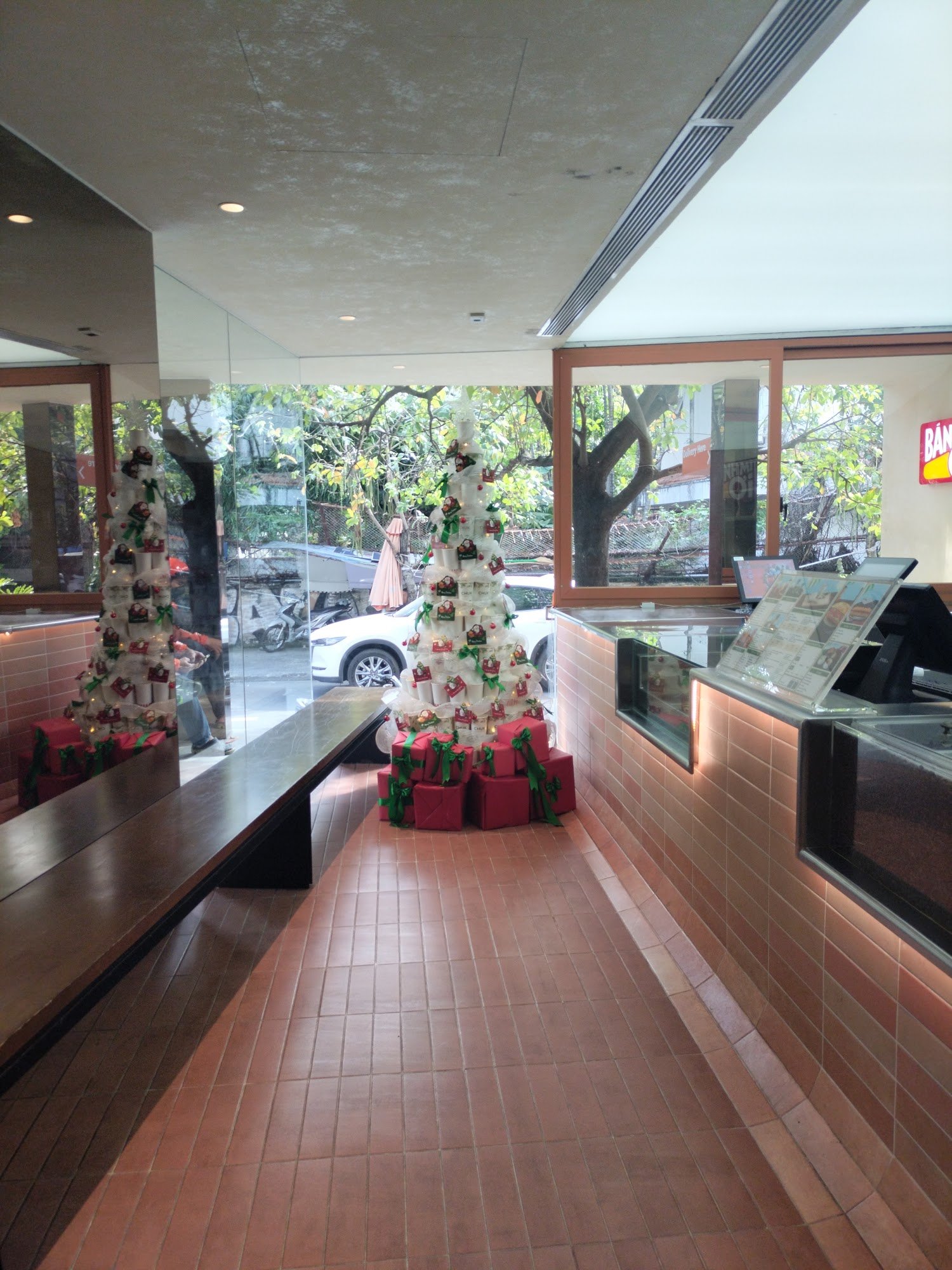 The image shows an indoor setting of a restaurant or cafe during the holiday season as indicated by the decorated Christmas tree with red and green or