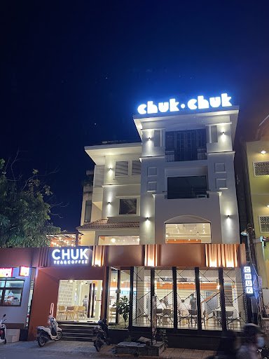 The image shows an exterior view of a modern two-story building at night illuminated by external lighting with the name 'chuk.chuk' prominently displa
