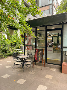 The image shows an exterior view of a cafe or restaurant located in Thao Dien, Saigon. The establishment has outdoor seating with tables and chairs on
