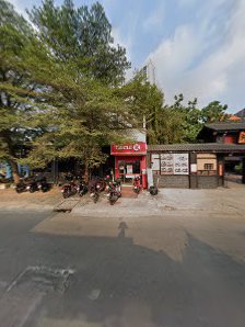 The image shows an exterior view of a small establishment named 'Taco' which appears to be a food outlet with red branding and signage, located on the