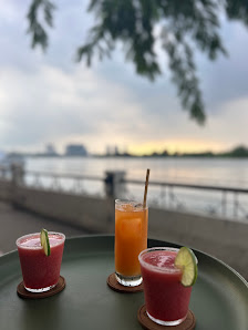 The image shows a table on an outdoor terrace overlooking water during twilight hours.