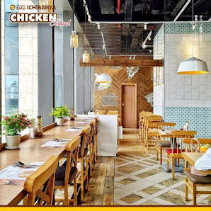 The image shows an interior view of a modern restaurant named 'Ichibany Chicken' located in Thao Dien, Saigon. The space features wooden tables and ch