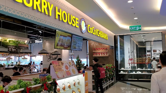 The image shows an interior view of a food court in Thao Dien, Saigon with various stalls including 'Curry House' and 'CoCo Ichibanya'. The area is we