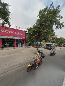 A street view showing a red storefront labeled 'Concung' and two motorbikes on the road in front of it.