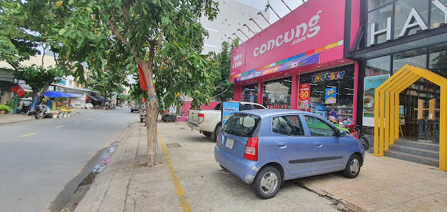 The image shows a street view of an urban area where there is a store named 'concung' with various products displayed in the front, including toys and