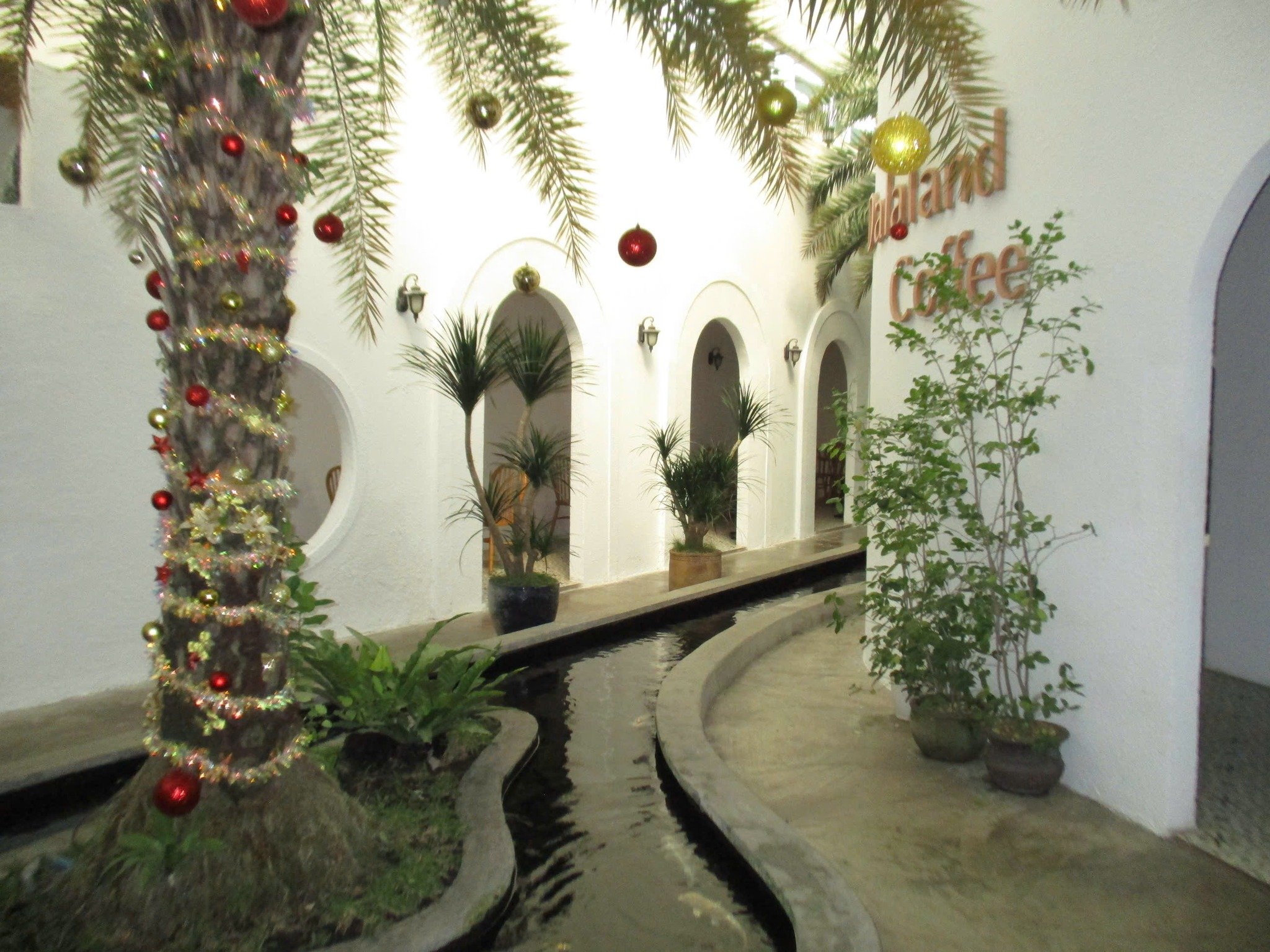 The image depicts an indoor setting that appears to be a part of Thao Dien in Saigon. It features white arched doorways leading into different areas, 