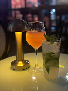 A close-up of a table featuring two glasses and an illuminated lampshade on the left side.