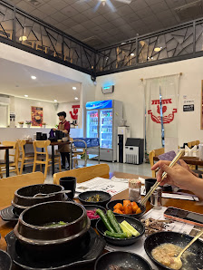 The image shows an indoor dining area where people are seated at tables enjoying a meal together.