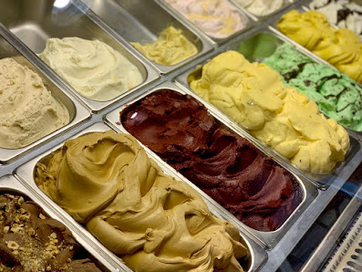 A close-up view of a selection of ice cream flavors in metal containers.