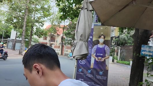 A street scene featuring a person walking past an outdoor advertisement for what appears to be a healthcare or medical service provider.