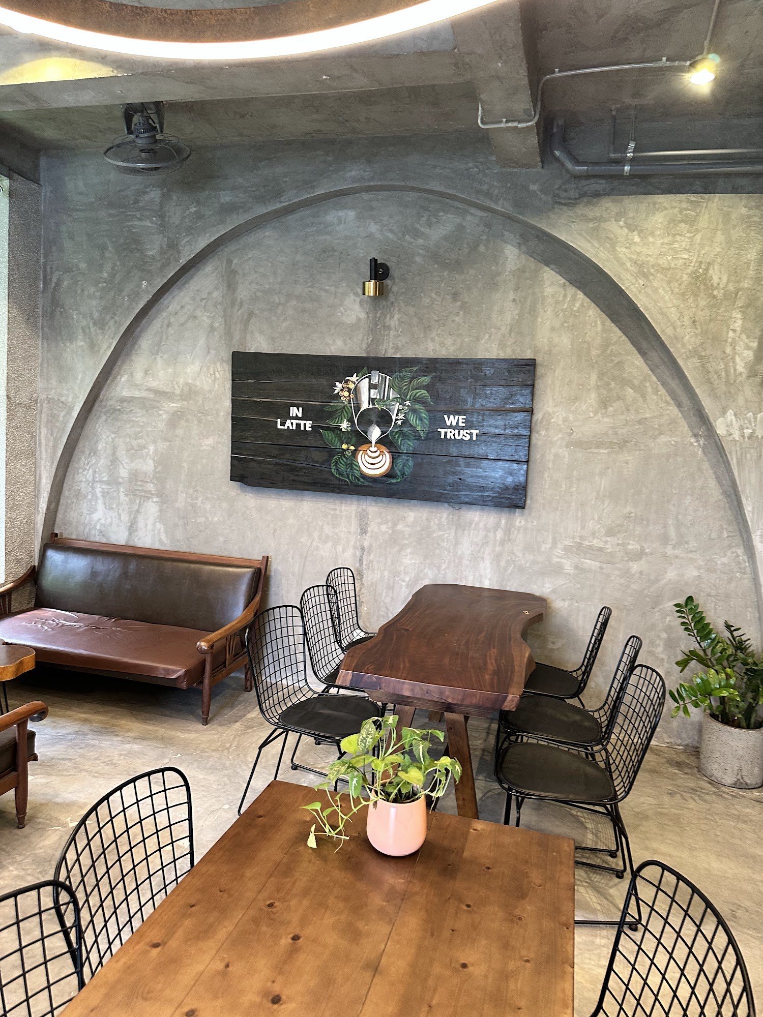 The image shows an interior space of a café or coffee shop in Thao Dien, Saigon. The decor features rustic elements such as exposed brick walls and wo