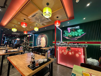 The image depicts the interior of a restaurant in Thao Dien, Saigon. It features wooden tables with black chairs, hanging lantern-style lights (red an