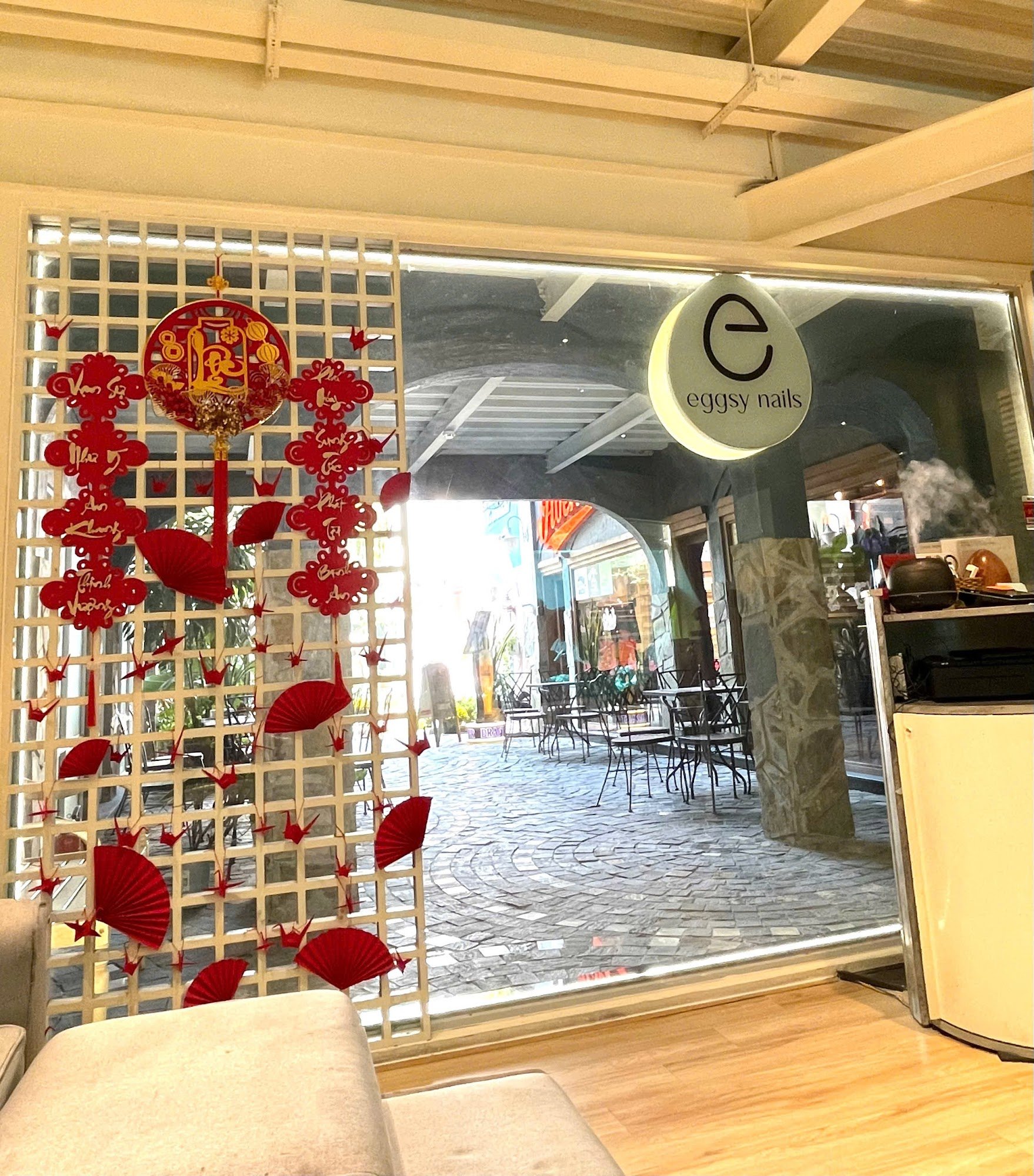 The image shows an interior view of a venue decorated for what appears to be the Lunar New Year celebrations with red decorations and lanterns on disp