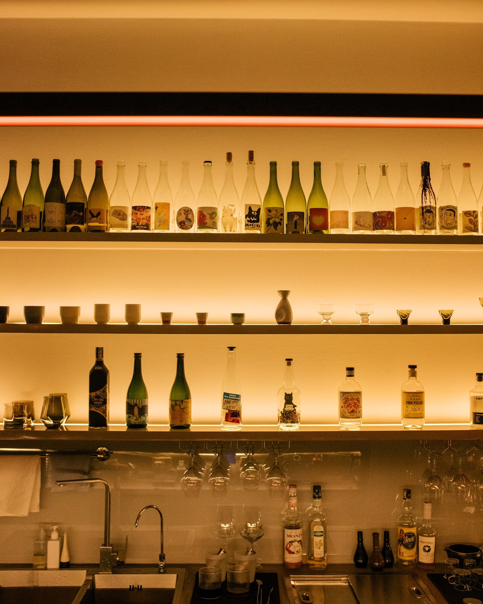 This image shows a well-stocked bar shelf in an indoor setting, likely within a restaurant or lounge venue named Thao Dien, Saigon.