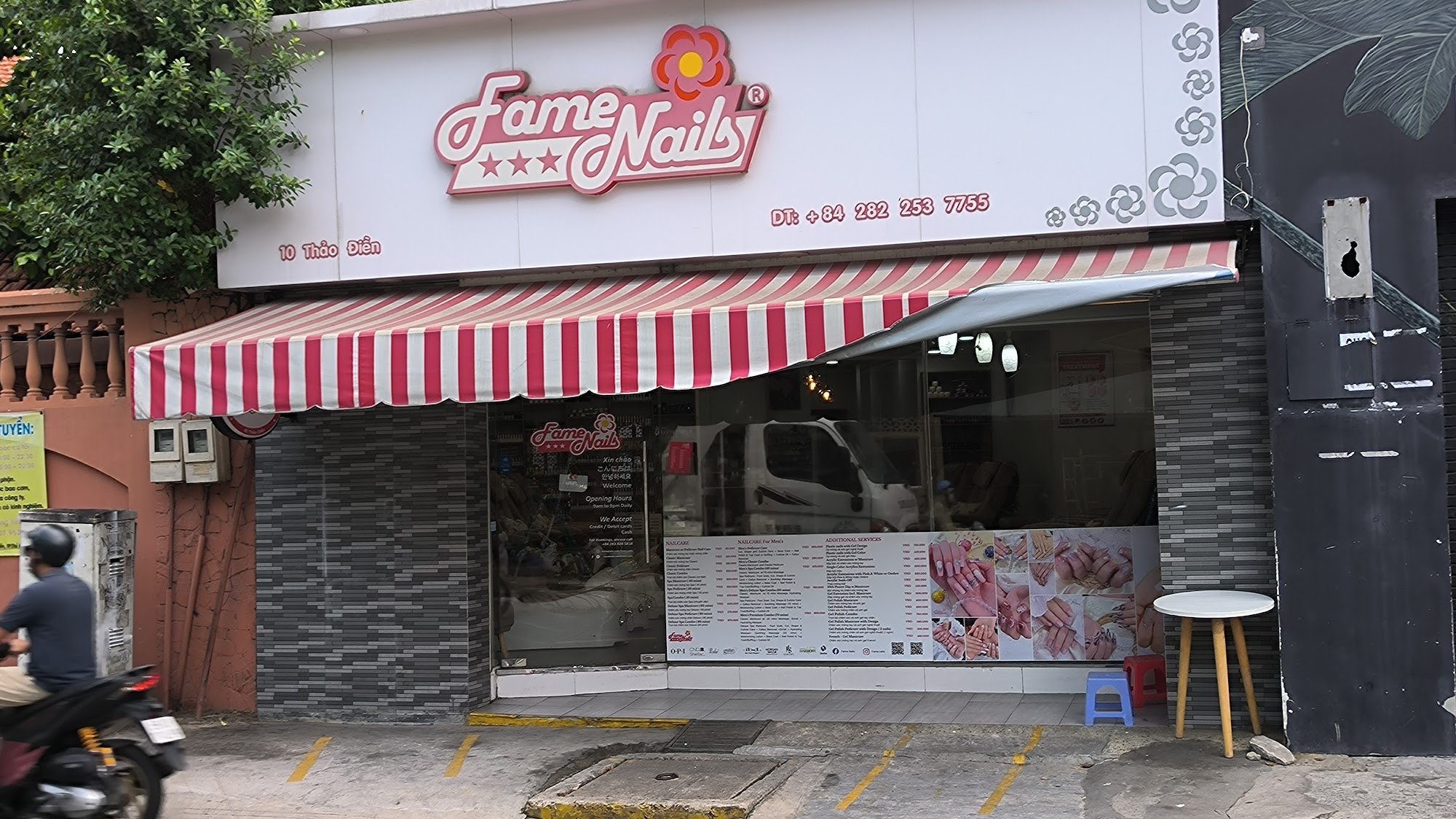 The image shows an exterior view of a nail salon named 'FameNails' located in Thao Dien, Saigon.