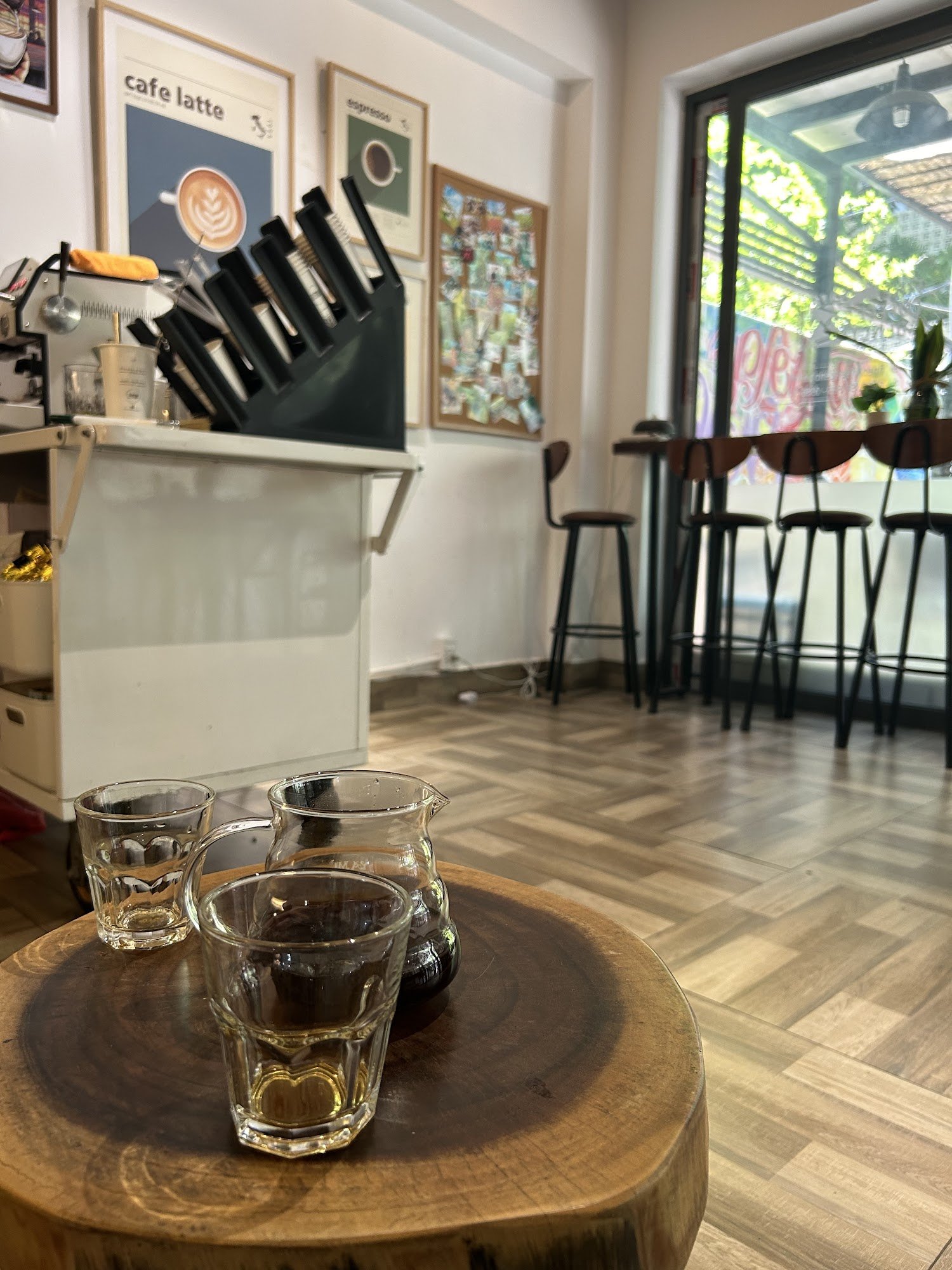 The image shows an interior view of a coffee shop or café in Thao Dien, Saigon. The focus is on the counter area with various items such as glasses an