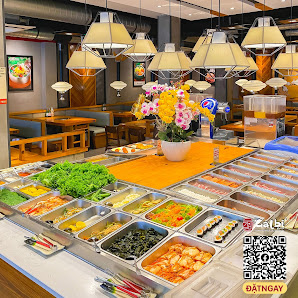 The image depicts the interior of a restaurant in Thao Dien, Saigon, featuring a buffet-style food display with various dishes in metal trays. The dis