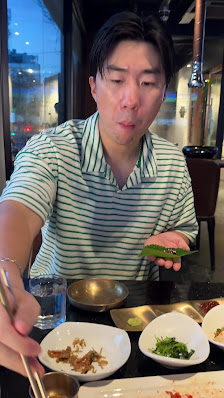 A person is seated at a table in what appears to be an indoor dining establishment with modern decor.