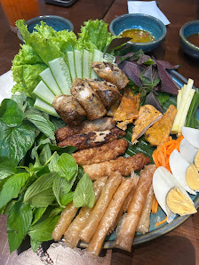 Plated Vietnamese meal with grilled chicken and spring rolls