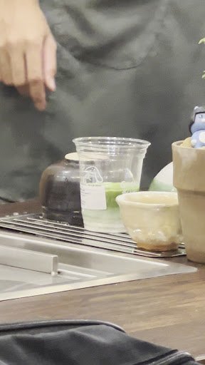 A close-up view of a countertop in what appears to be an interior setting with various items such as cups and containers, possibly for food or drink p