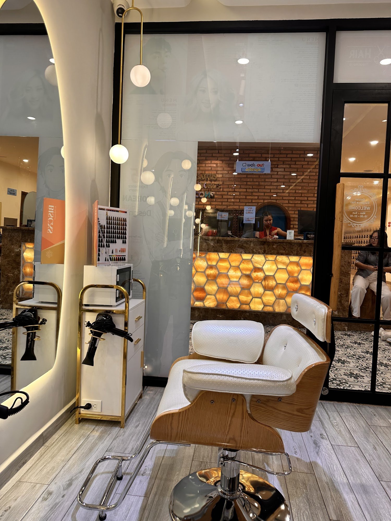 The image depicts an interior view of a modern hair salon or barbershop located in Thao Dien, Saigon. The space features contemporary design elements