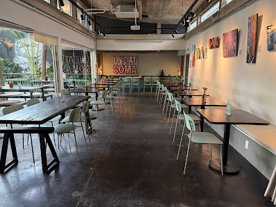 The image shows an interior view of a restaurant or cafe named 'THAT WEAT SOHO'. The space is modern with exposed brick walls, large windows allowing