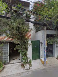 The image shows a residential building in Thao Dien, Saigon. It features an open garage with various items stored inside and outside the entrance area