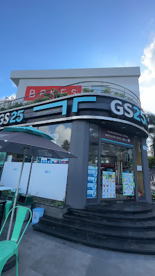 The image shows an exterior view of a modern storefront named 'GS25', which appears to be a convenience store or small supermarket with the name promi