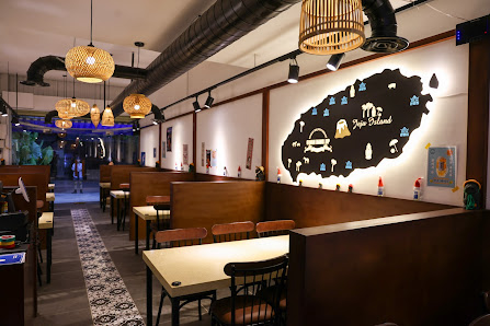 The image depicts the interior of a restaurant in Thao Dien, Saigon. It features wooden booths and tables with chairs, hanging woven pendant lights, e