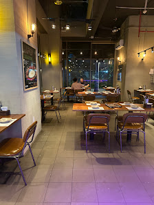 The image shows an interior view of a restaurant or cafe in Thao Dien, Saigon. The space is modern with industrial elements such as exposed ceiling be