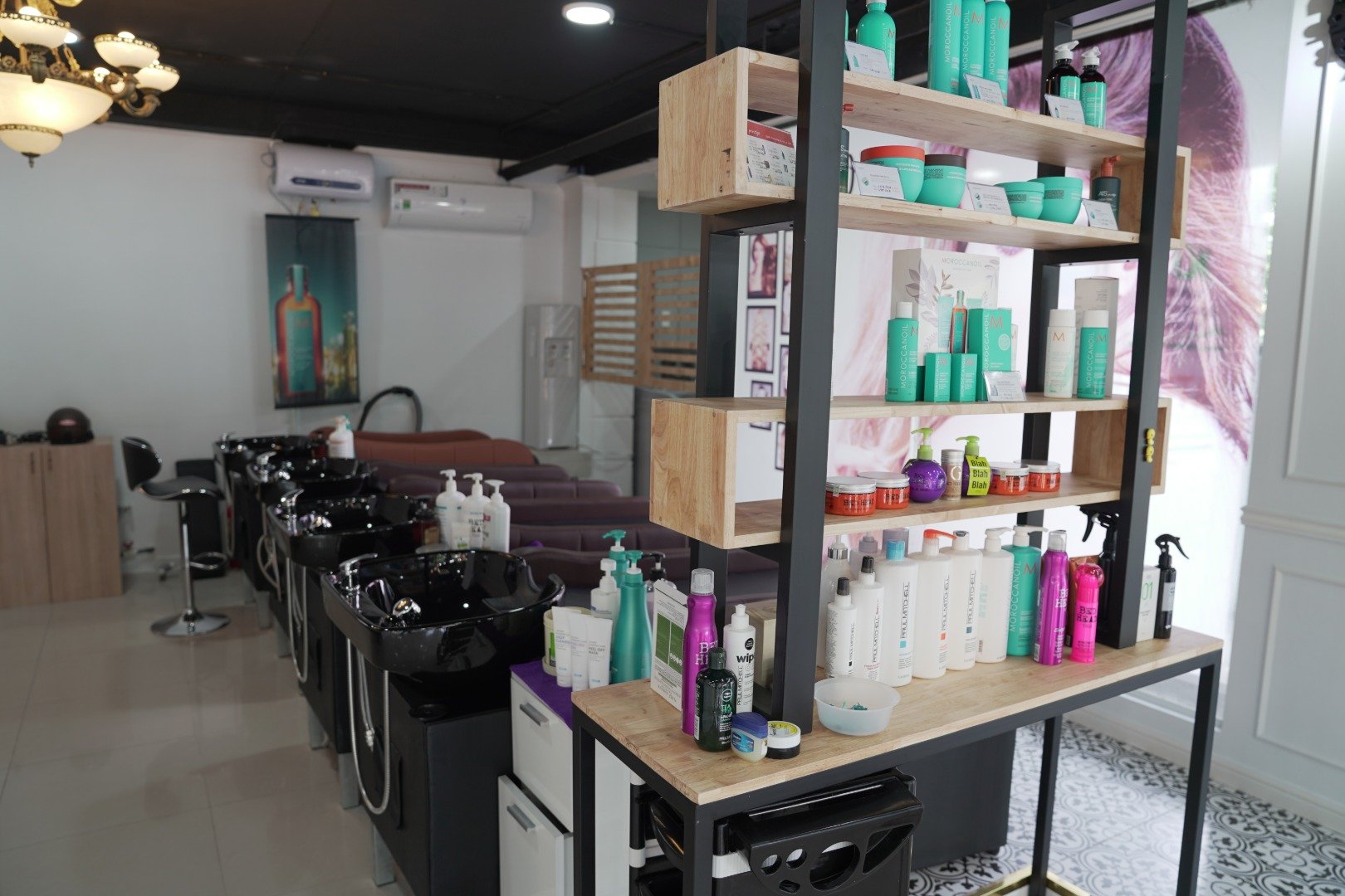 The image shows a well-organized hair salon interior featuring modern styling stations equipped with black chairs and silver bowls for washing clients
