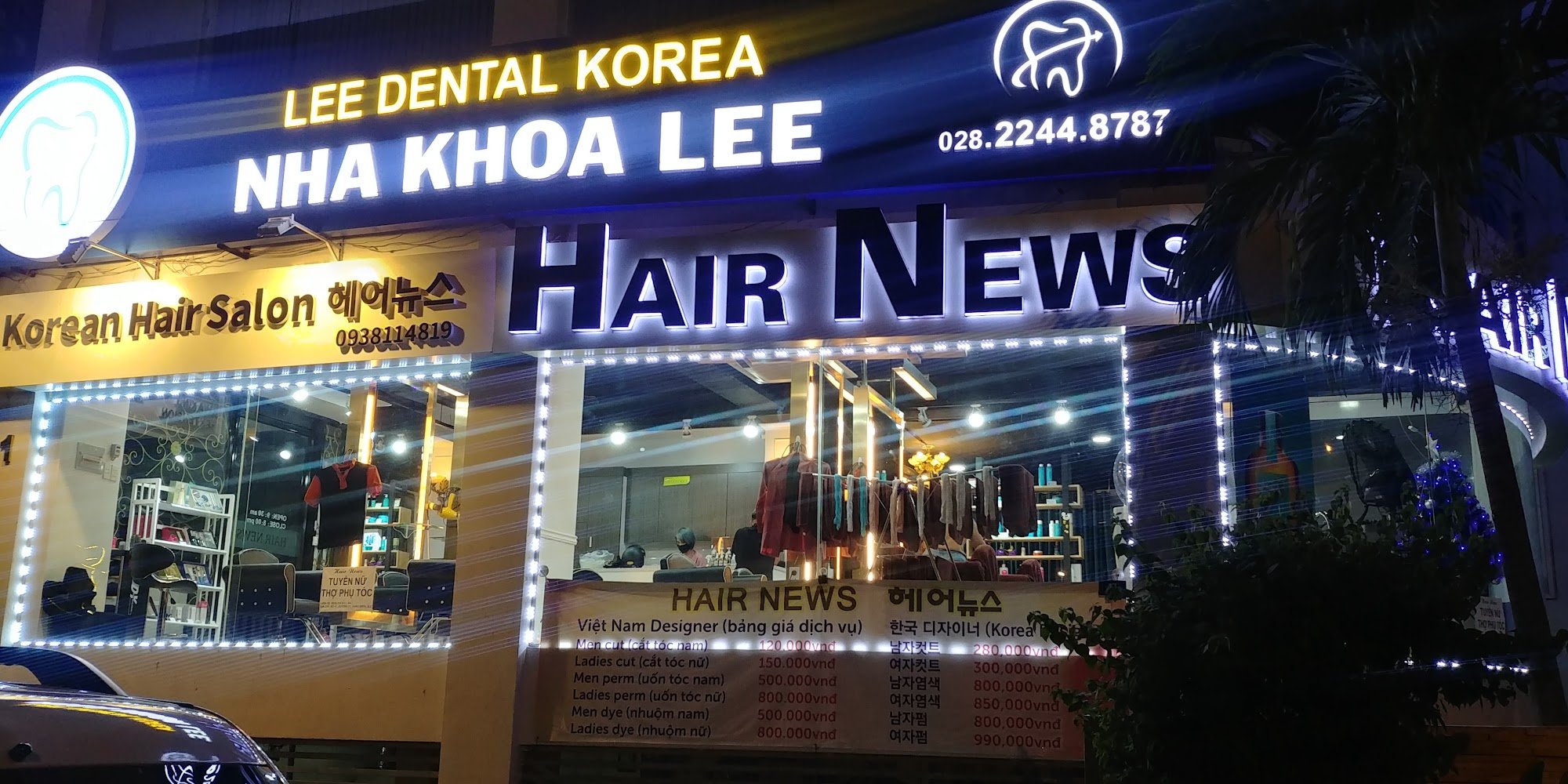 The image shows an exterior view of a business establishment at night time in Thao Dien, Saigon. The signage indicates it is named 'LEE DENTAL KOREA'