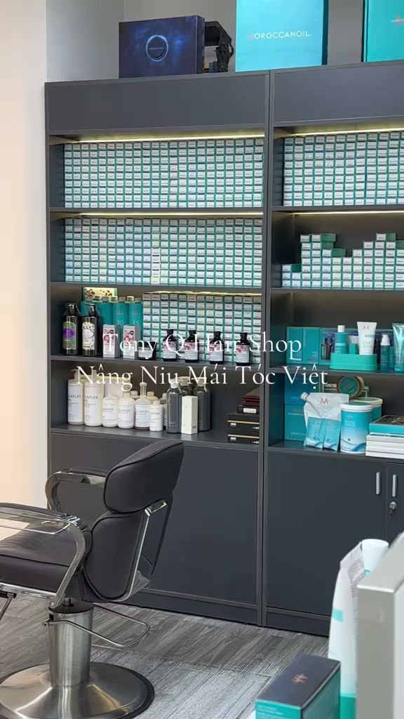 The image shows a well-organized interior of what appears to be a beauty or hair salon with various products displayed on shelves and in cabinets, alo