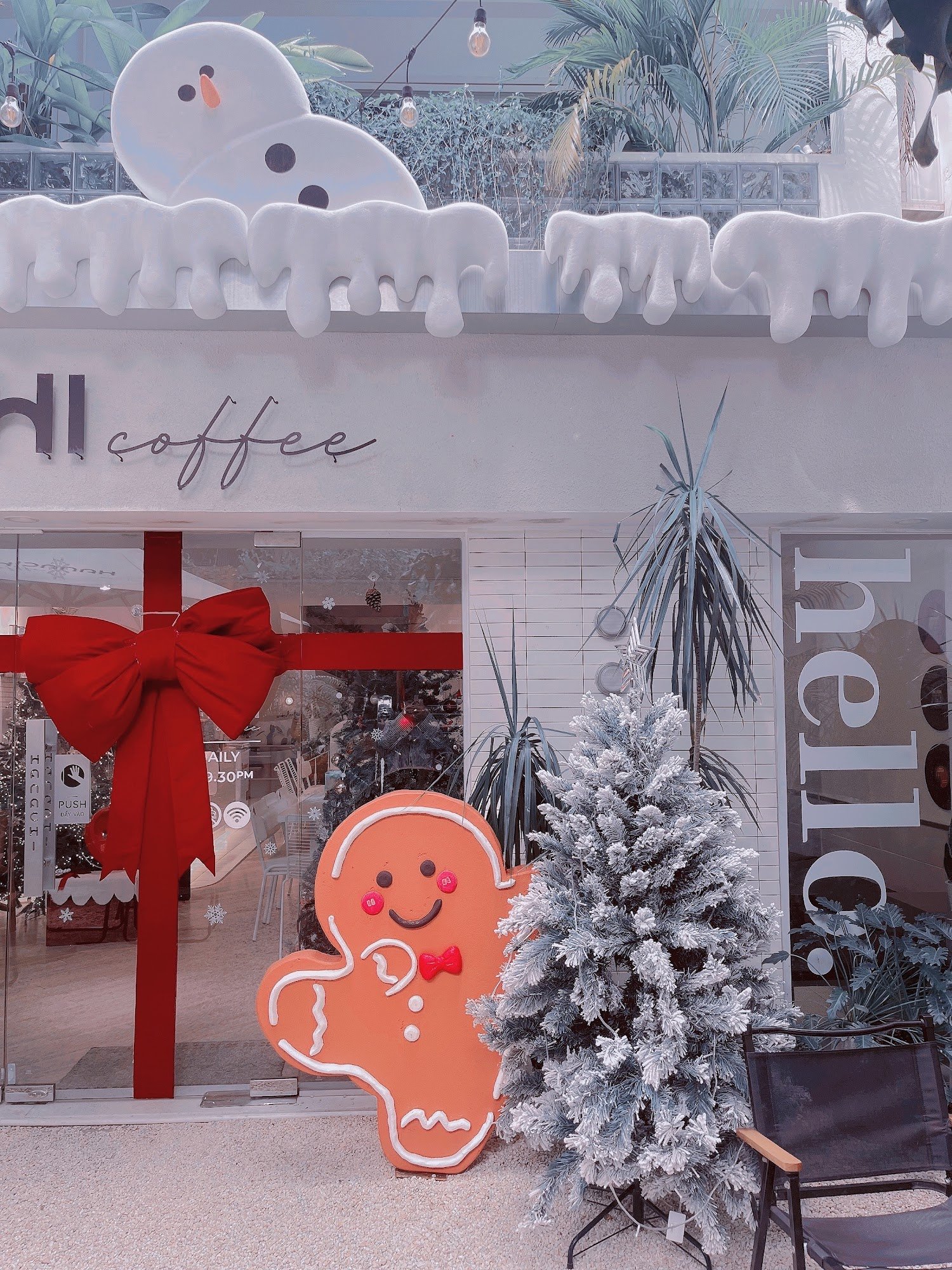 The image shows a festive exterior of a coffee shop named 'Hill Coffee'. Decorations include a large gingerbread man, a red bow on the door, and snowm