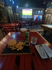The image shows an indoor dining area of a restaurant or bar named 'High Time'. The setting includes red wooden tables and chairs, with various food i