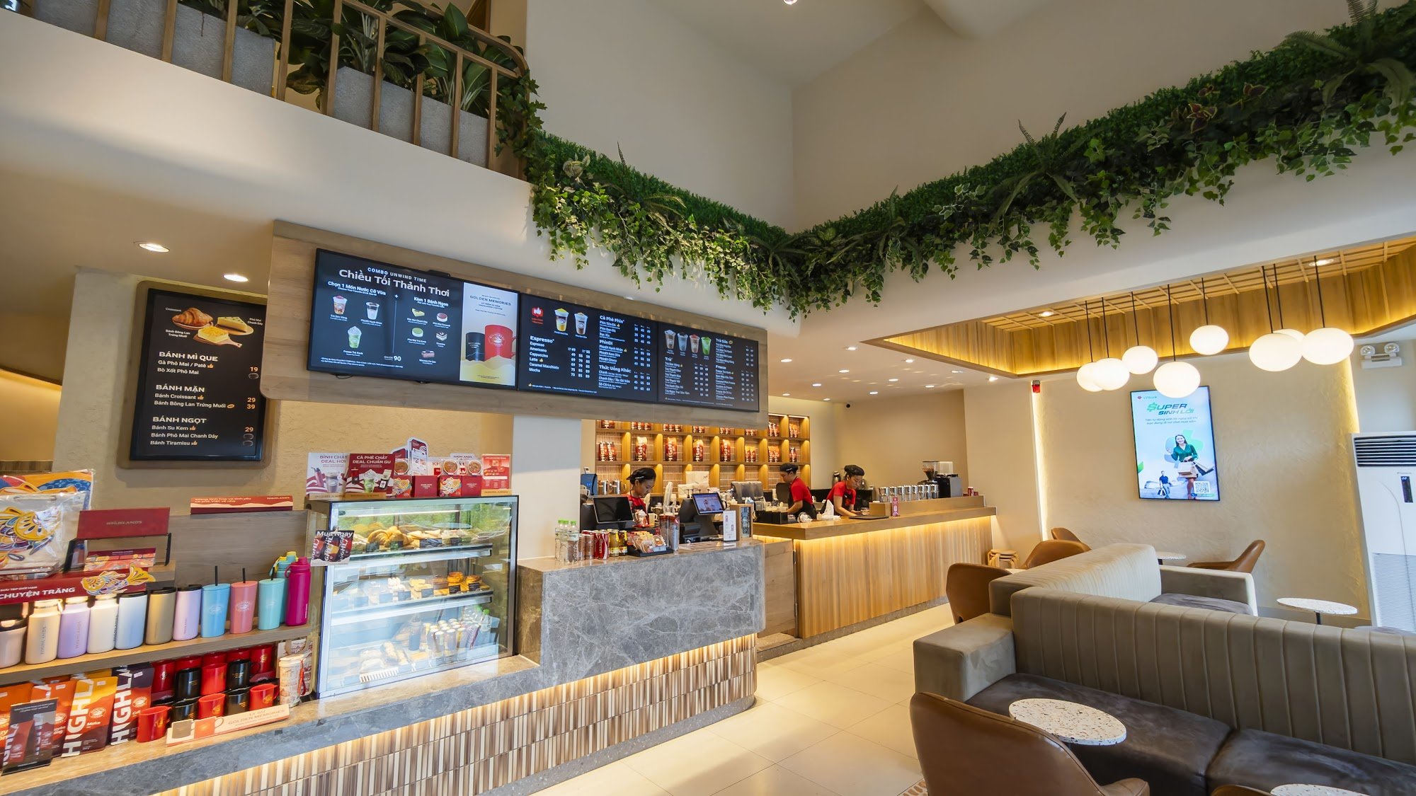 The image depicts an interior view of a modern coffee shop or fast-food restaurant in Thao Dien, Saigon. The space is well-lit with warm lighting and 