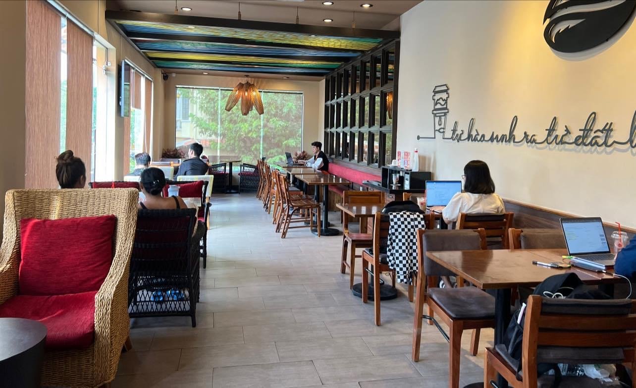 The image shows an interior view of a cafe or restaurant named 'Thao Dien'. It features wooden tables and chairs, some with checkered cushions, along